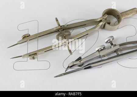 A companion for drawing circles on a white piece of paper. Drafting accessories for drawing technical drawings. Light background. Stock Photo