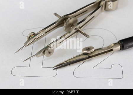 A companion for drawing circles on a white piece of paper. Drafting accessories for drawing technical drawings. Light background. Stock Photo