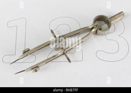 A companion for drawing circles on a white piece of paper. Drafting accessories for drawing technical drawings. Light background. Stock Photo