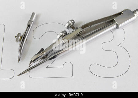 A companion for drawing circles on a white piece of paper. Drafting accessories for drawing technical drawings. Light background. Stock Photo
