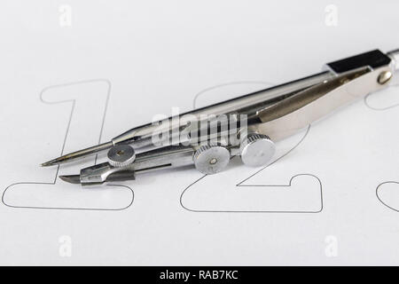 A companion for drawing circles on a white piece of paper. Drafting accessories for drawing technical drawings. Light background. Stock Photo