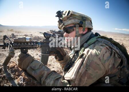 Sgt. Bryan Ryder, 1st Battalion, 24th Infantry Regiment, Ft. Wainright, Alaska, pulls security during the training exercise, NTC 17-03, National Training Center, Ft. Irwin, CA., Jan. 13, 2017. The National Training Center conducts tough, realistic, Unified Land Operations with our United Action Partners to prepare Brigade Combat Teams and other units for combat while taking care of Soldiers, Civilians, and Family members. Stock Photo