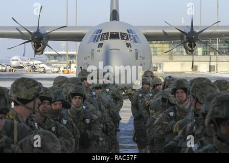 Paratroopers assigned to Chosen Company, 2nd Battalion, 503rd Infantry Regiment, 173rd Airborne Brigade, prepare to board a C-130 Hercules aircraft during an airborne operation departing from Riga International Airport in Riga, Latvia, Jan. 11, 2017. Freezing conditions honed the Paratroopers’ ability to conduct operations in harsh environments and in support of Latvian forces. The ‘Sky Soldiers’ of 2nd Bn., 503rd Inf. Regt. are on a training rotation in support of Operation Atlantic Resolve, a U.S. led effort in Eastern Europe that demonstrates U.S. commitment to the collective security of NA Stock Photo