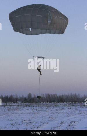CAMP ADAZI, Lativa – A Paratrooper assigned to Chosen Company, 2nd Battalion, 503rd Infantry Regiment, 173rd Airborne Brigade, descends on the drop zone at Adazi Training Area, Latvia during an airborne insertion Jan. 11, 2017. Freezing conditions honed the Paratroopers’ ability to conduct operations in harsh environments and in support of Latvian forces. The ‘Sky Soldiers’ of 2nd Bn., 503rd Inf. Regt. are on a training rotation in support of Operation Atlantic Resolve, a U.S. led effort in Eastern Europe that demonstrates U.S. commitment to the collective security of NATO and dedication to en Stock Photo