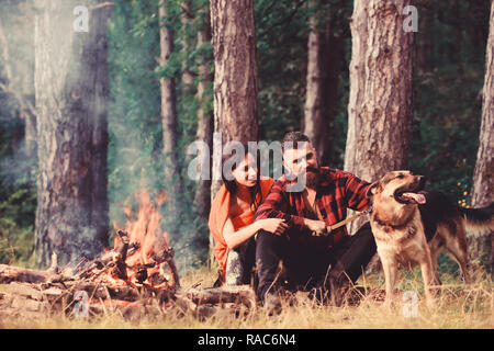 https://l450v.alamy.com/450v/rac6n4/couple-in-love-or-young-happy-family-spend-time-together-family-relax-concept-couple-with-german-shepherd-dog-near-bonfire-forest-background-woman-man-and-dog-on-vacation-hiking-camping-rac6n4.jpg