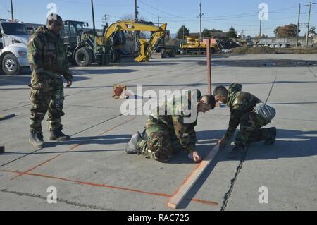 Members of the 374th Civil Engineer Squadron create lines for others to cut the cement during a simulated crater repair scenario at Yokota Air Base, Japan, Jan. 12, 2017. The training provides Airmen with the opportunity to practice and hone their skillset for potential real world scenarios. Stock Photo