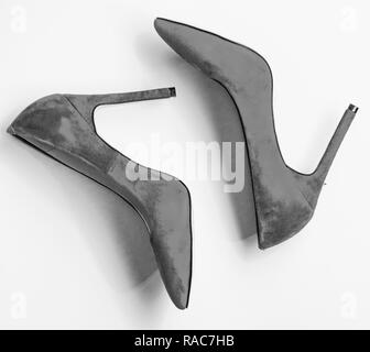 Footwear with thin high heels, stiletto shoes, top view. Shoes made out of red suede on yellow background. Pair of fashionable high heeled pump shoes. Feminine shoes concept. Stock Photo