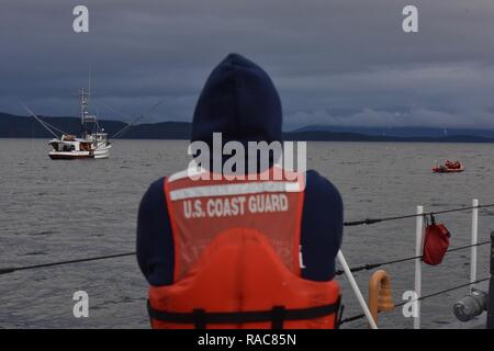 Petty Officer 1st Class Thomas McLendon watches from the Coast Guard Cutter Anacapa while a Coast Guard law enforcement team prepares to board the fishing vessel Silver Tip in the Icy Straits of Alaska, Jan. 14, 2017.     The Coast Guard Cutter Anacapa is a 110-ft patrol boat homeported in Petersburg, Alaska.    Coast Guard Stock Photo
