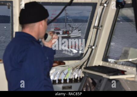 Lt. Peter Vermeer, commanding officer of the Coast Guard Cutter Anacapa, contacts his boarding team via VHF-FM radio while they prepare to conduct a maritime law enforcement boarding in the Icy Straits of Alaska, Jan. 14, 2017.     The Coast Guard Cutter Anacapa is a 110-ft patrol boat homeported in Petersburg, Alaska.    Coast Guard Stock Photo