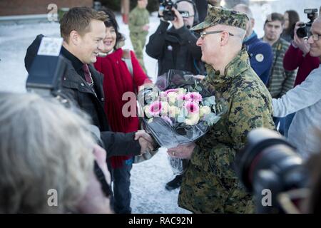 U.S. Marine Col. Doug Bruun, Marine Corps liaison team Officer in Charge in Norway receives flowers as a welcoming gift from Mayor Ivar Vigdenes, of Stjørdal in Vaernes, Norway, Jan. 16, 2017. A limited contingent of U.S. Marines began rotating in and out of Norway in early 2017 to train with Norwegian military personnel in support of U.S. European Command requirements. Stock Photo