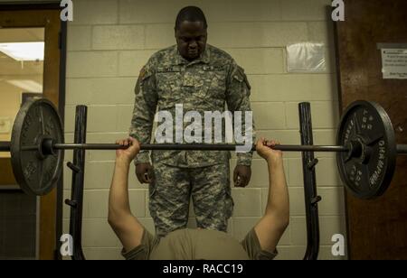 U.S. Army Reserve Private 1st Class Dunta Smith, a logistical supply specialist from Atlanta, Ga., spots Sgt. Christopher Duncan, of Columbus, Ga., as they exercise during their lunch break in the 335th Signal Command (Theater) headquarters building in East Point, Ga., Jan. 21, 2017. Both soldiers are with Charlie Company, 324th Expeditionary Signal Battalion. Stock Photo