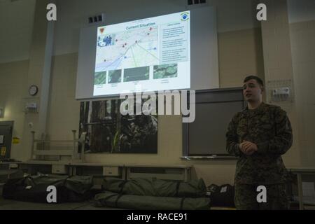 U.S. Marine Corps Lance Cpl. Devin S. Dobson, an intelligence specialist assigned to Marine Heavy Helicopter Squadron (HMH) 464, gives an intelligence brief to Marines during Exercise Frigid Condor in Brunswick, Maine, Jan. 21, 2017. Dobson gave the brief to simulate a military threat assessment for the exercise. Stock Photo