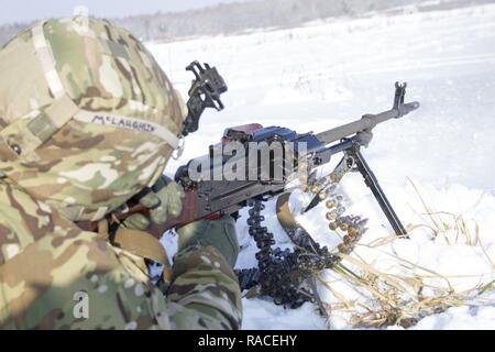 Sgt. David McLaughlin of Yukon, Oklahoma fires a PKM machine gun during instructor standardization training at the International Peacekeeping and Security Center, near Yavoriv, Ukraine, on Jan. 19. McLaughlin is a member of Company A, 1st Battalion, 179th Infantry Regiment, 45th Infantry Brigade Combat Team. He and other members of Company A were instructed on use of the AKM rifle and PKM machine gun to familiarize themselves with the weapons before they begin partnering with and mentoring Ukrainian army combat training center staff. Stock Photo