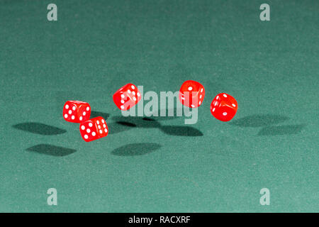 Five red dices falling on a green table Stock Photo