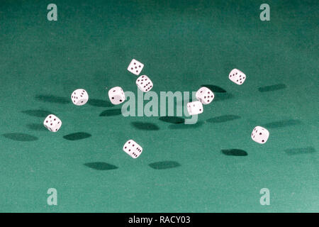 Ten white dices falling on a green table Stock Photo