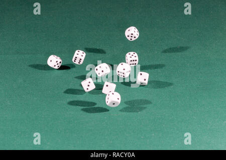 Ten white dices falling on a green table Stock Photo