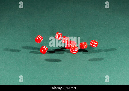 Ten red dices falling on a green table Stock Photo