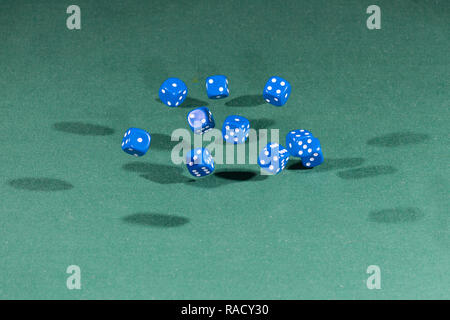 Ten blue dices falling on a green table Stock Photo