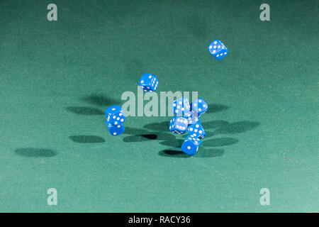Ten blue dices falling on a green table Stock Photo