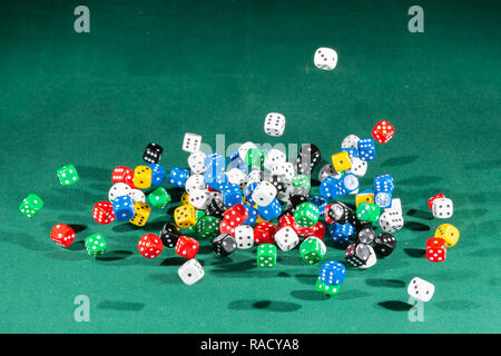 Hundred colored dices falling on a green table Stock Photo