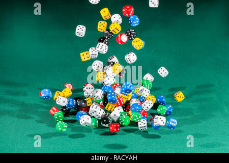Hundred colored dices falling on a green table Stock Photo