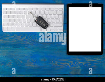 Business Workplace with wireless keyboard, tablet computer and car keys on blue wooden background. Office desk with copy space. Empty space for text Stock Photo