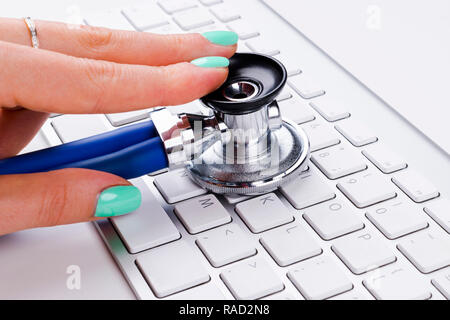 technician female (woman) hand using stethoscope for examines computer keyboard, computer service concept, computer and internet maintenance, checking Stock Photo