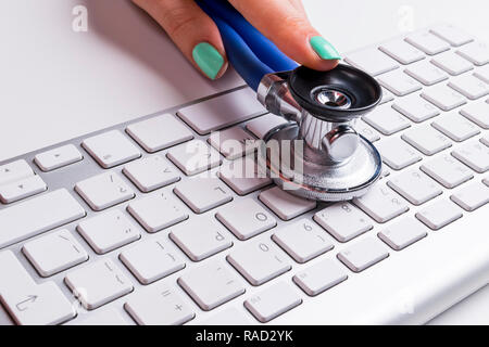 Close up view of a Computer notebook keyboard with one blue button on office white table, technology background, empty space for text Stock Photo