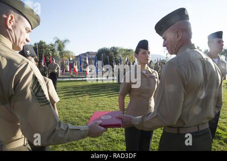 U.S. Marine Sgt. Maj. Troy E. Black, sergeant major of 1st Marine Logistics Group passes the Junior Sailor of the Quarter award to Brig. Gen. David A. Ottignon, commanding general of the 1st MLG, to present to Petty Officer 2nd Class Amber Barak at Camp Pendleton, Calif., Jan 26, 2017. Barak is a hospital corpsman with Combat Logistics Regiment 15, 1st MLG. During this ceremony, Marines and Sailors received awards based on stellar performance, excellent leadership, and outstanding unit safety contributions during the quarter or year. Stock Photo