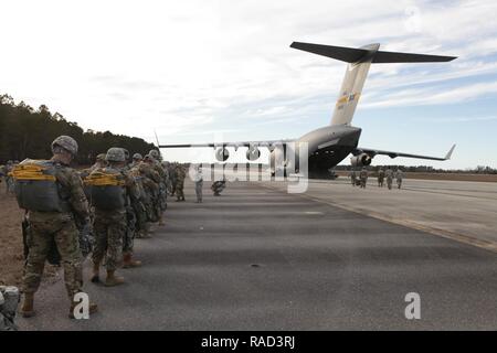 U.S. Army paratroopers assigned to the 360th Civil Affairs Brigade and other supporting units prepare to board a U.S. Air Force C-17 Globemaster for a mass tactical Airborne jump for Operation Anvil in North Air Force Auxiliary Base, North, South Carolina, Jan. 26, 2017. The 360th Civil Affairs Brigade hosts Operation Anvil so jumpmasters can perform duties and jumpers can maintain currency for jump status. Stock Photo