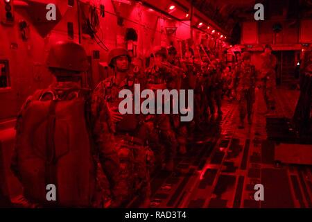 U.S. Army paratroopers assigned to the 360th Civil Affairs Brigade and other supporting units hook their universal static lines to exit a U.S. Air Force C-17 Globemaster for a mass tactical Airborne jump for Operation Anvil in North Air Force Auxiliary Base, North, South Carolina, Jan. 26, 2017. The 360th Civil Affairs Brigade hosts Operation Anvil so jumpmasters can perform duties and jumpers can maintain currency for jump status. Stock Photo