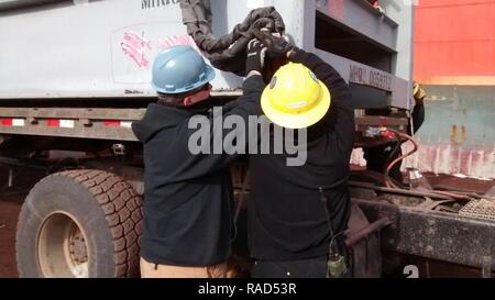 ANTARCTICA (Jan. 29, 2017) Cargo Handlers, Sailors assigned to Navy Cargo Handling Battalion ONE (NCHB-1), remove the shackle from the container placed on the trailer for movement to the marshaling yard at the National Science Foundation's McMurdo Station Antarctica. NCHB-1 is the military logistics component supporting the U.S. Antarctic Program in Operation DEEP FREEZE. Stock Photo