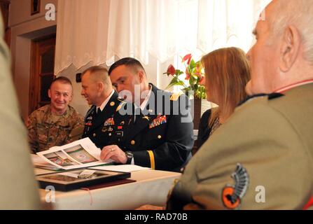 Col. Christopher Norrie, commander of 3rd Armored Brigade Combat Team, 4th Infantry Division looks through Polish army retired Lt. Col. Jan Kudla’s awards and medals during a visit, along with Command Sgt. Maj. Christopher Gunn, and  (not pictured) Brig. Gen. Stanislaw Czosnek and Command Sgt. Maj. Robert Zych, command team of the 11th Armored Cavalry Division Jan. 31, 2017, in Zielona Gora, Poland.  Kudla joined the Polish army as an officer in 1941 and fought in battles in France, Germany, Belgium and the Netherlands during World War II. For his bravery during the war, he was awarded the Cro Stock Photo