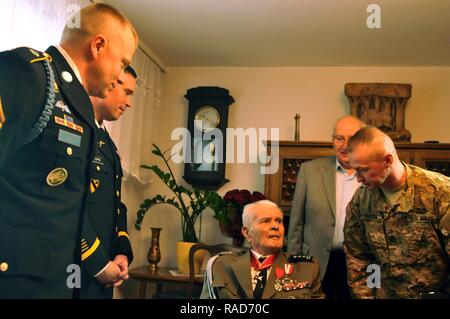 Staff Sgt. Tomasz Sobota, an infantryman working as a Polish linguist, assigned to 3rd Armored Brigade Combat Team, 4th Infantry Division greets Polish army retired Lt. Col. Jan Kudla, along with Command Sgt. Maj. Christopher Gunn and Col. Christopher Norrie, command team of 3rd ABCT, 4th ID during a visit to Kudla’s home to show their respect for his dedication and sacrifice to his country while serving in the Polish army during World War II, Jan. 31, 2017, in Zielona Gora, Poland.  Kudla joined the Polish army as an officer in 1941 and fought in battles in France, Germany, Belgium and the Ne Stock Photo