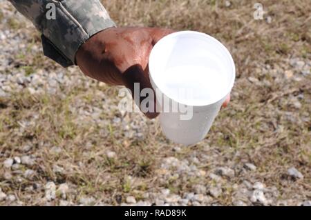 Pfc. Kirenski Fletcher, a water purification specialist assigned to the 351st Aviation Support Battalion, Alpha Company, Hartsfield South Carolina, shows a cup with freshly purified water from Hagler pond at Camp Shelby, Hattiesburg, Miss., Jan. 31. The of soldiers traveled to Mississippi to participate in the PATRIOT South 17 exercise. Stock Photo