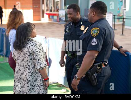 Two Houston Police Officers help two patrons of Super Bowl events with directions at Discovery Green in downtown Houston, Jan. 31, 2017. Law enforcement agencies from accross the country and U.S. territories came together to provide a safe event for fans and patrons of Super Bowl 51. U.S. Coast Guard Stock Photo