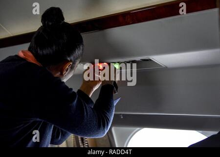 Tech. Sgt. Vanessa Schook, 99th Airlift Squadron flight attendant, performs a pre-flight safety inspection on a C-20B at Joint Base Andrews, Maryland, Jan. 27, 2017. FAs are safety experts, customs specialists and culinary artists, often preparing meals from scratch at 30-to-40,000 feet, while ensuring the safety of the crew and passengers at all times. Stock Photo