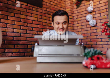 stylish man is sitting on a typewriter in a festive mood with a glass Stock Photo