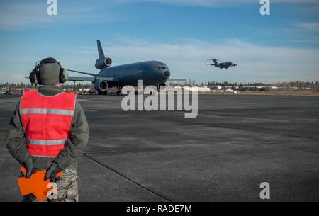 Senior Airman William Roten, 821st Contingency Response Squadron maintainer, prepares to marshal a KC-10 Extender aircraft from Travis Air Force Base, Calif., Jan. 23, 2017, at Joint Base Lewis-McChord, Washington. Airmen from the 821st Contingency Response Group, exercised their capability to support humanitarian efforts during exercise Dragon Breath at JBLM and Fairchild Air Force Base. Stock Photo