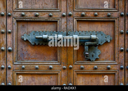 Backgrounds and textures: ancient wooden door, closed with traditional forged metal lock Stock Photo