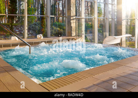 Luxurious hot tub spa in boutique hotel with big glass windows with nature view. Stock Photo