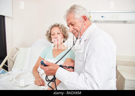 Doctor makes blood pressure measurement in a patient to control high blood pressure Stock Photo