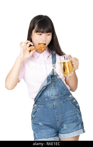 Beautiful Chinese American woman eating a fried chicken drumstick and a mug of beer isolated on a white background Stock Photo