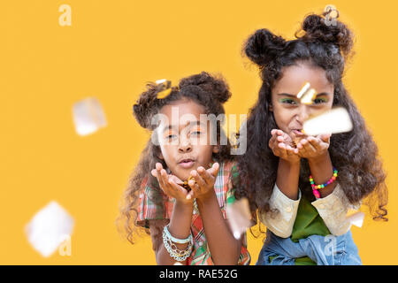 Nice afro American girls blowing foil pieces at you Stock Photo
