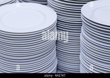 large stacks of clean white plates after washing in the kitchen Stock Photo