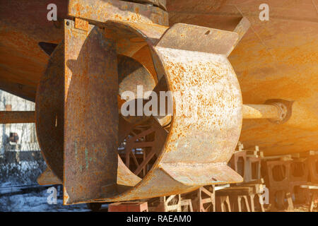 Rusty screw in the nozzle, the rudder and shaft of the ship, standing in a dry dock during the repair Stock Photo