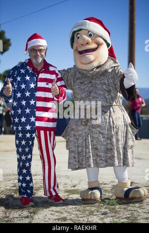 Curt Stanley, left, owner of Adventures in Advertising, and the San Diego Padres team mascot the Swinging Friar, during the Secret Santa event hosted by the Armed Services Young Men’s Christian Association at Marine Corps Base (MCB) Camp Pendleton, California, Dec. 13, 2018. The Secret Santa program gives San Diego County businesses, civic organizations and community members the opportunity to give back to service members stationed at Camp Pendleton by donating gifts to junior enlisted service members families during the holiday season. Stock Photo