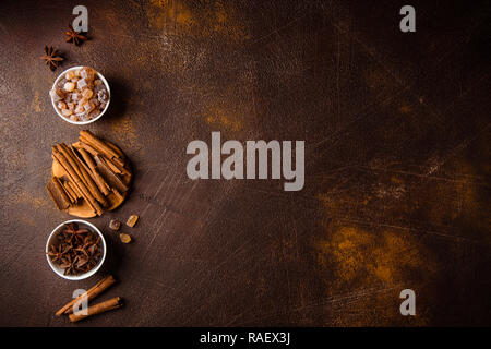 Cinnamon sticks, anise sprouts and caramelized sugar on a dark background. View from above. Close-up. Stock Photo