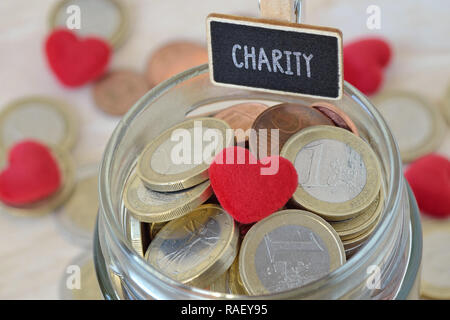 Euro coins and heart in glass money jar with Charity label - Charity concept Stock Photo