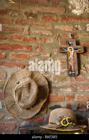 Used farmer straw hats hung on a wall, beautiful vintage background Stock Photo